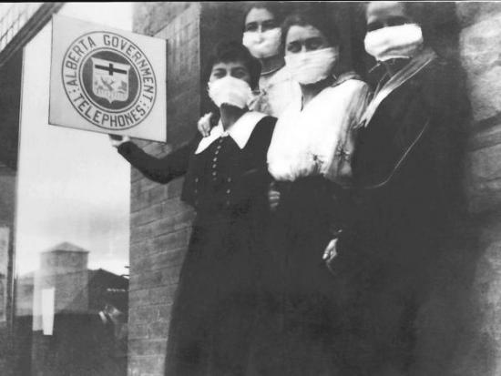 Black and white photograph of young women wearing masks standing outside a telegraph office.
