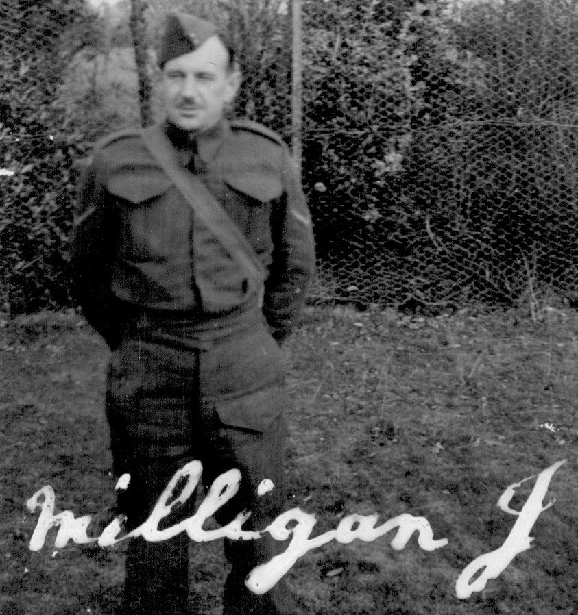 Black and white photo of a man standing on grass wearing a World War Two army uniform.
