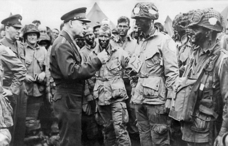 General Eisenhower speaks to men in military uniforms during World War Two.