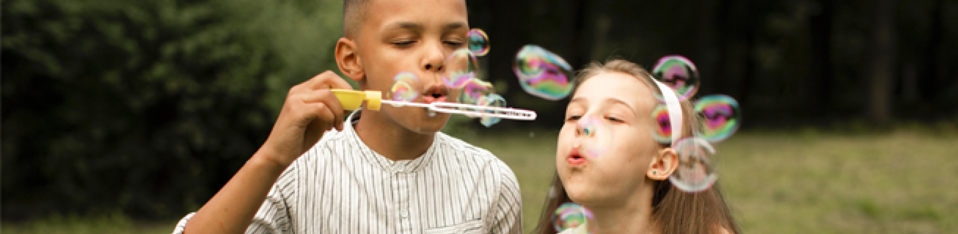 Children blowing bubbles and making friends outside