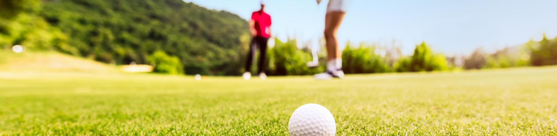 golfer putting golf ball into hole