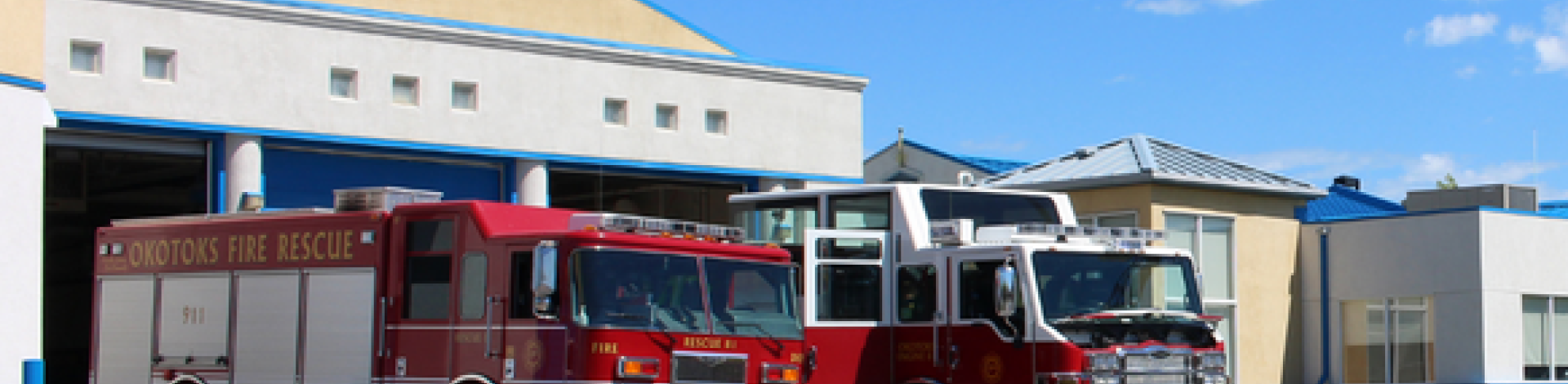 Photo of Okotoks fire department and two fire trucks parked infront