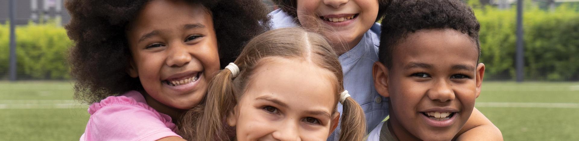 ethnically diverse children hugging each other in a park