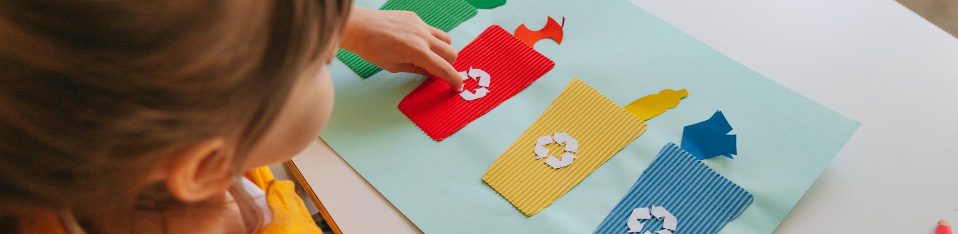 Child with craft on organics waste sorting