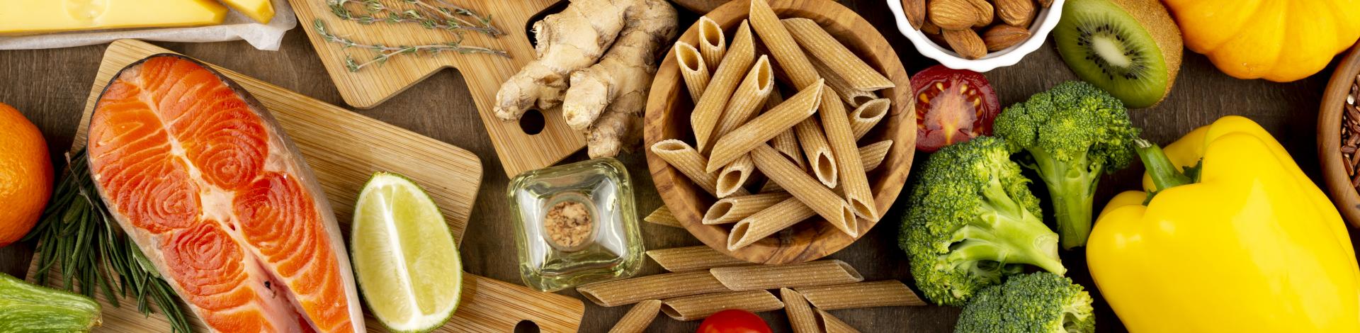 Assortments of food including dried pasta, vegetables, raw salmon, chicken and beef