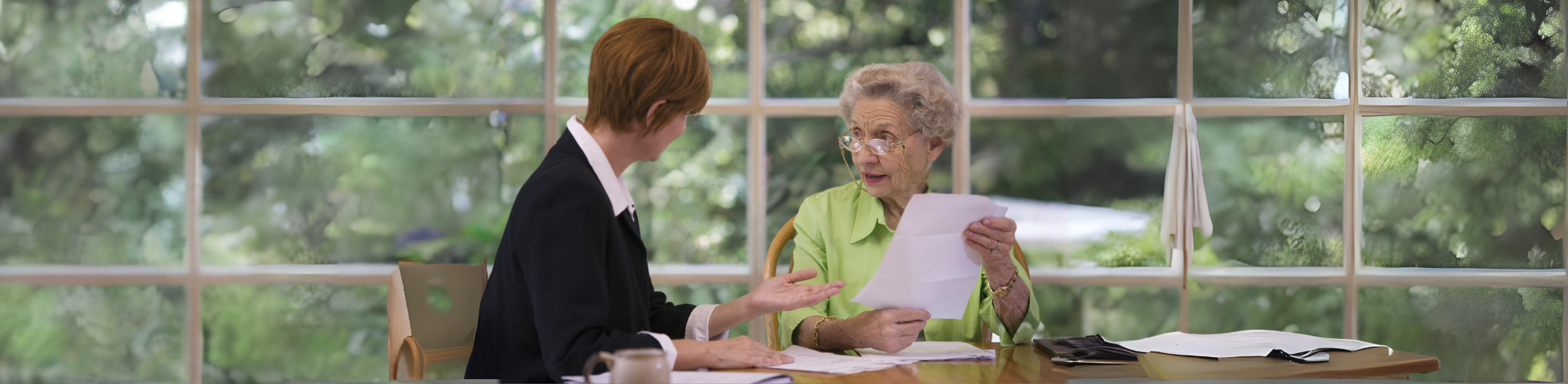 Woman helping senior lady with paperwork