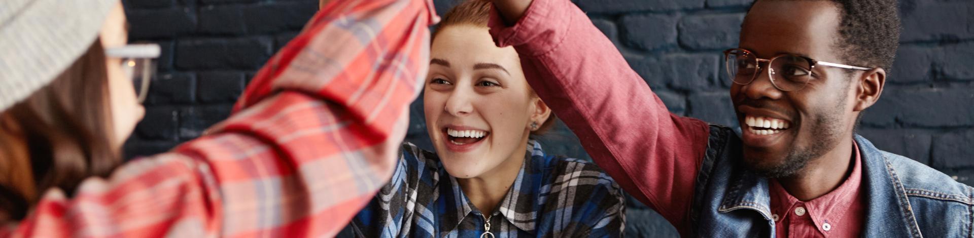 One male and two females sharing a high five