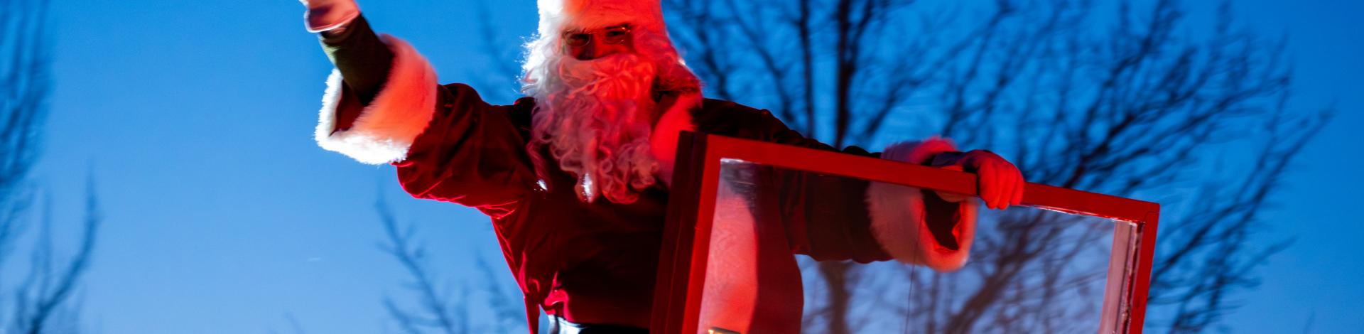 Santa waving on top of a fire truck during Okotoks Christmas Eve Parade
