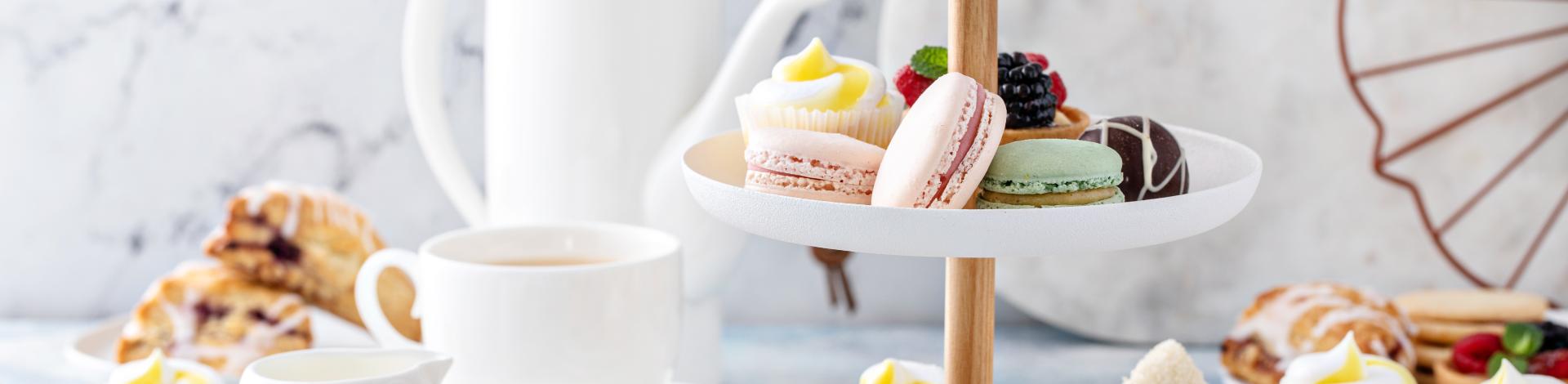 a setting for high tea with baked goods and cups