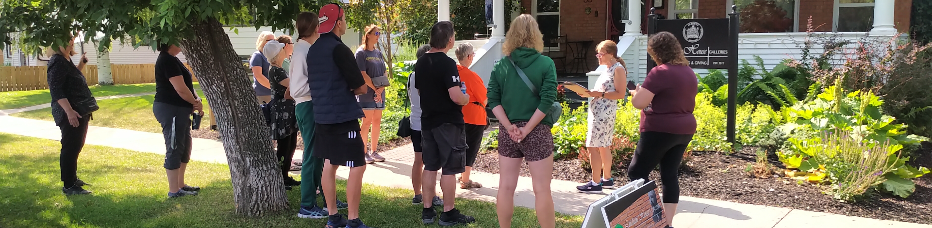 a group of people stand listening to a tour guide