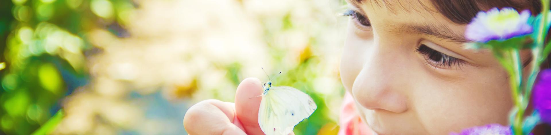 little girl with a butterfly in a garden
