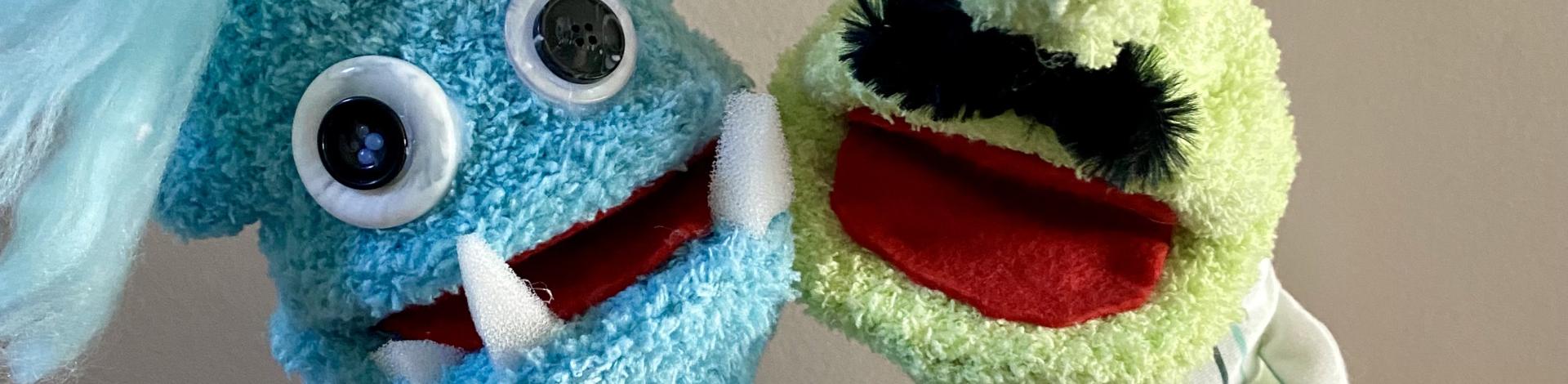 Two hand and rod puppets with big googly eyes and fangs. 