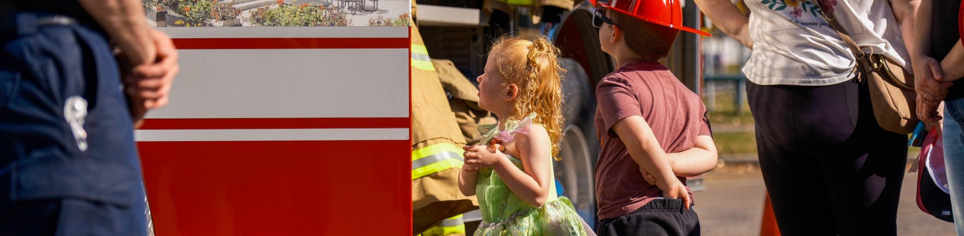 Young kids looking up at an Okotoks fire engine during Fire Prevention Week