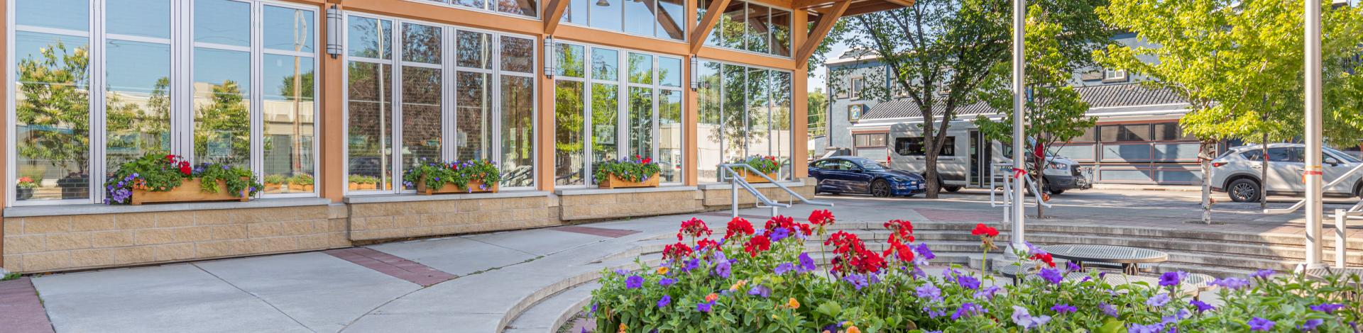 Okotoks Municipal Centre in summer with flowers blooming out front