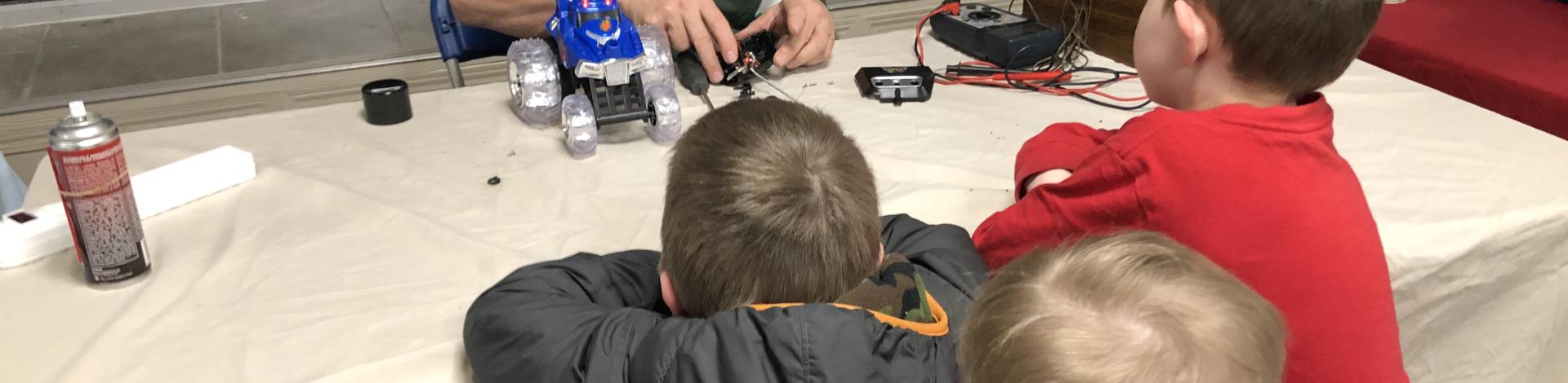 Repair Cafe volunteers fixing children's toy