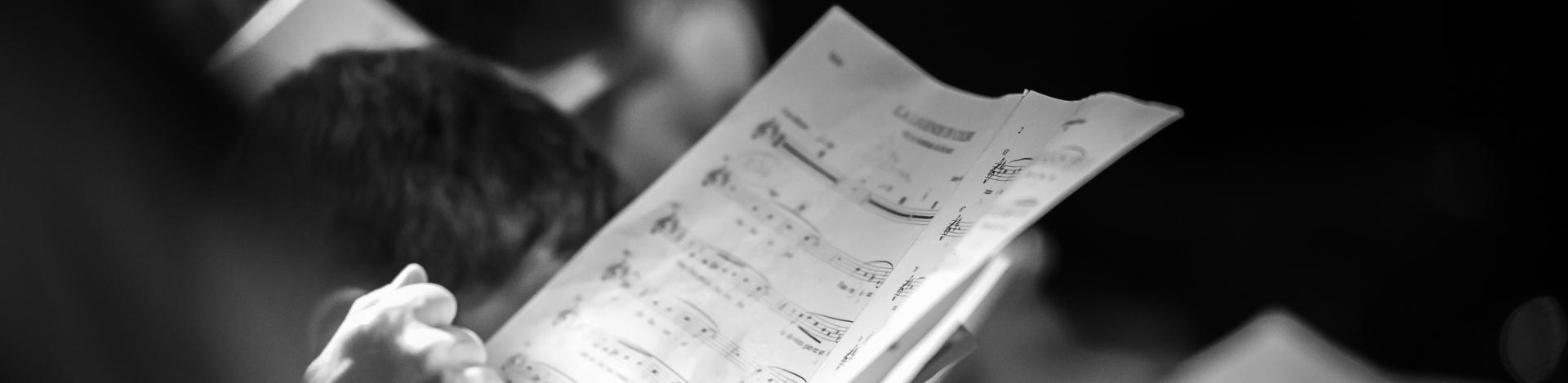 Hand holding music score in choir