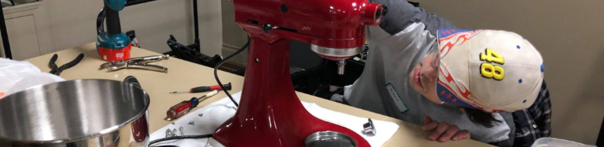 A man repairs a mixer at a repair cafe