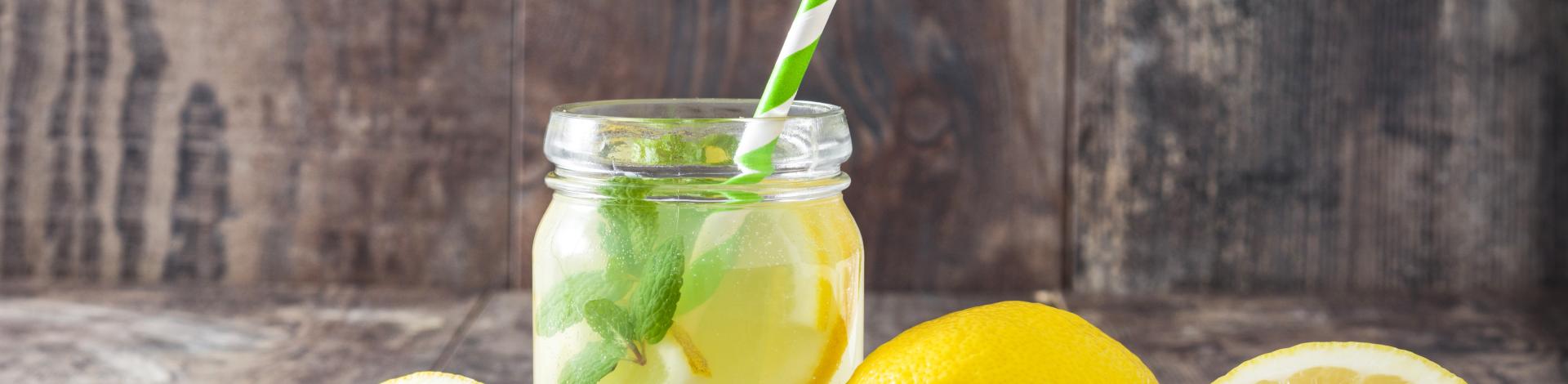 Lemonade drink in a jar glass on wooden background