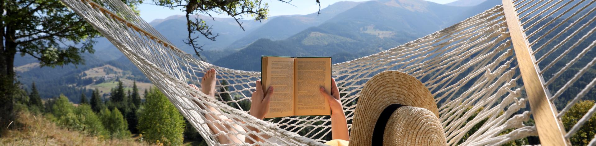 Young woman reading book in hammock