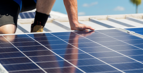 man on roof installing solar panels