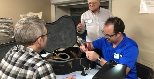 Repair Cafe volunteers fixing a musical instrument - guitar