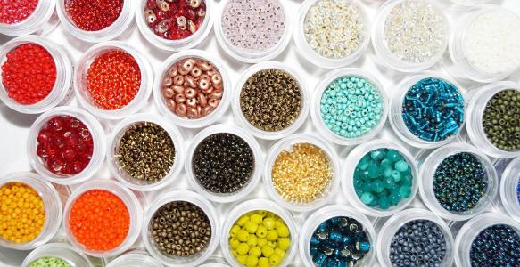 Small bowls of beads in all the colours of the rainbow.