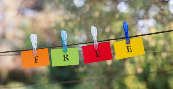word-free-spelled-colorful-papers-hanging-rope-attached-by-clothes-peg-outside-green-nature