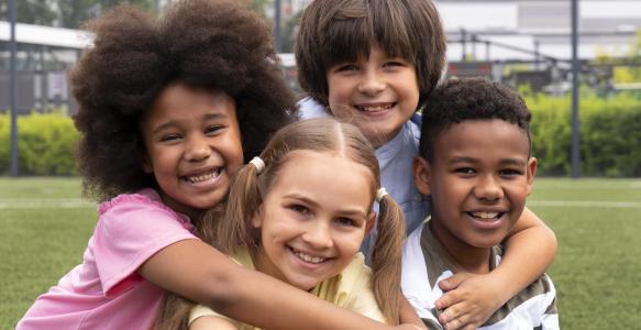 ethnically diverse children hugging each other in a park