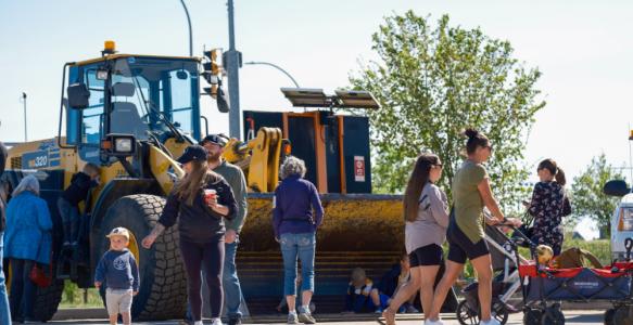 people walking in front of a loader 
