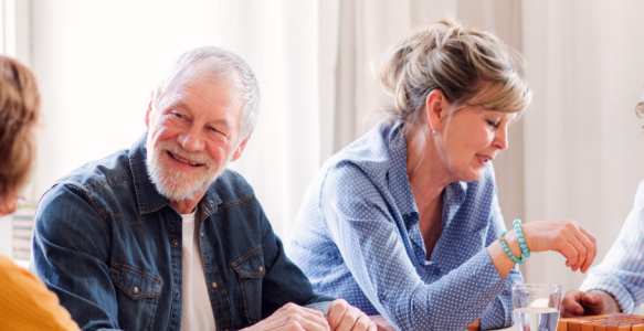 four older adults engaging in conversation and laughing