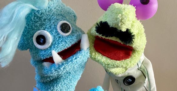 Two hand and rod puppets with big googly eyes and fangs.