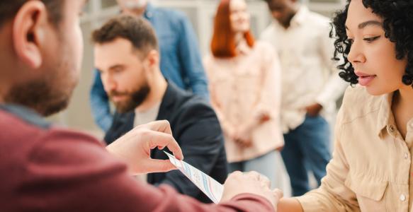 multiracial-group-people-african-american-woman-sitting-registration-table-filling-out-ballot