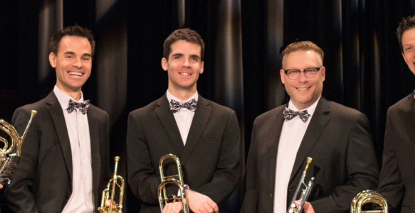 Five brass band members standing in tux
