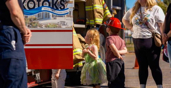 Young kids looking up at an Okotoks fire engine during Fire Prevention Week