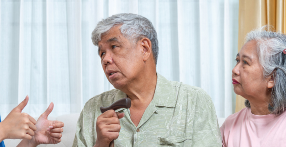 A health practitioner speaks to two seniors