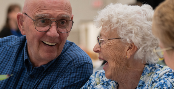 A group of seniors is seen chatting and laughing with one another
