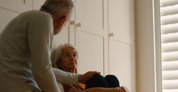 Two seniors share an intimate conversation in their home