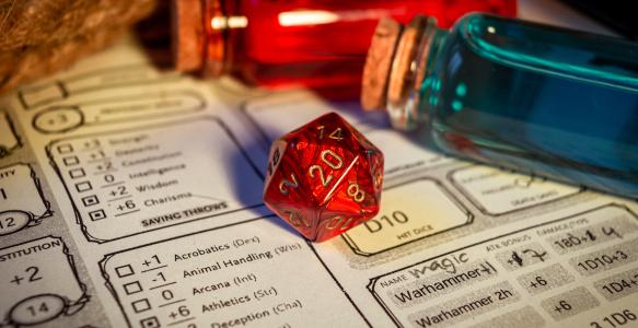 Close-up of a red d20 on a character sheet
