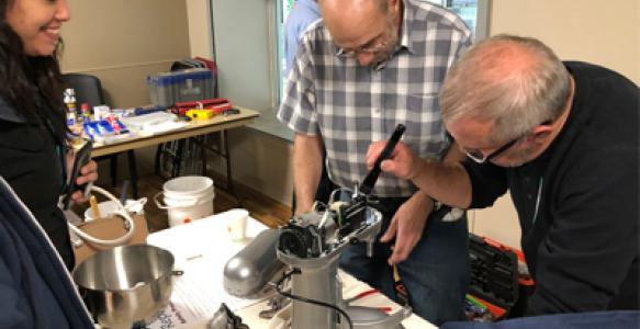 Repair Cafe volunteers fixing house appliance