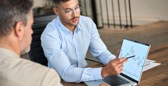 Two busy business men analysts doing finance on laptop