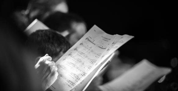 Hand holding music score in choir
