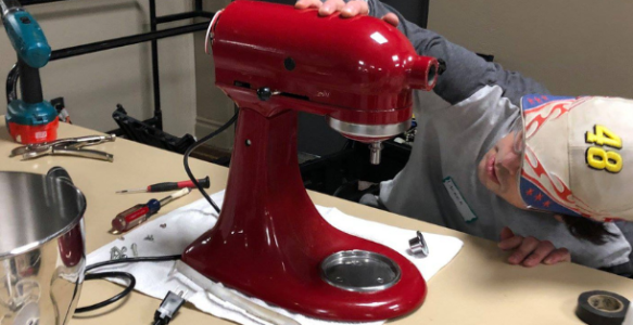 A man repairs a mixer at a repair cafe