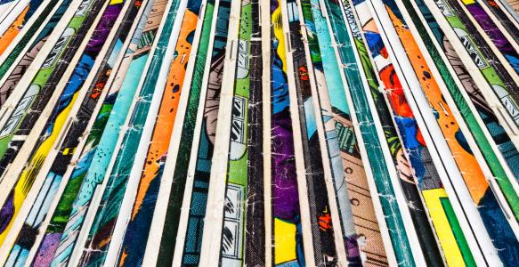 Stack of old comic books creates colorful background texture