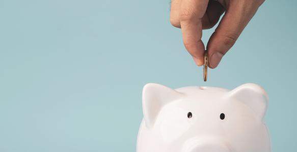 coin to white piggy bank saving
