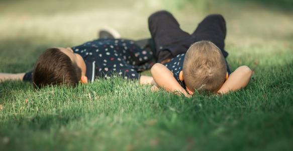 Boys laying in the grass watching clouds