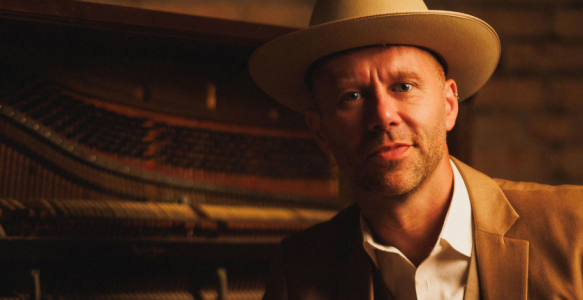 Jeffery Straker in front of a piano