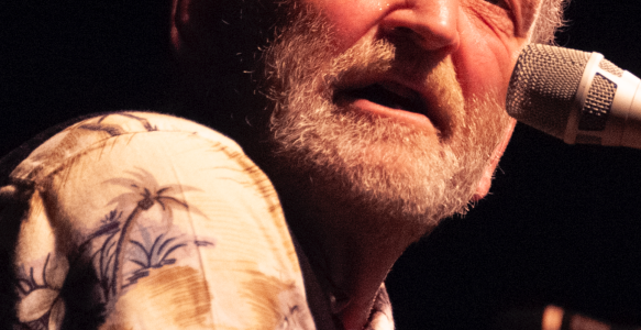 valdy singing on a stage