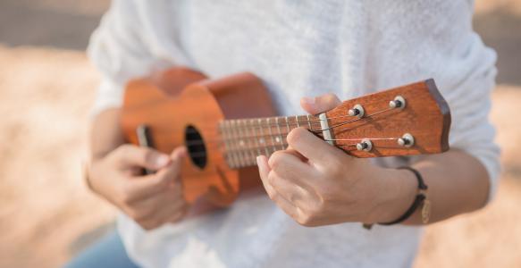 Young woman playing on Ukulele