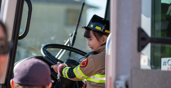 Kid behind the wheel of a fire truck