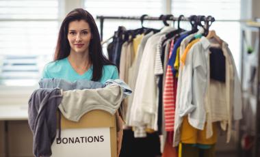 female-volunteer-holding-clothes-donation-box-to-swap-or-donate